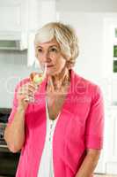 Thoughtful senior woman holding white wine