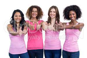Women in pink outfits showing their thumbs up