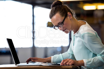 Woman looking a chart and using a laptop