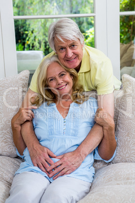 Happy senior couple embracing in living room at home