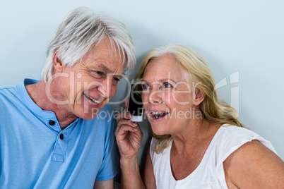 Retired couple listening to music through smartphone