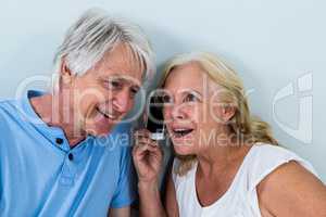 Retired couple listening to music through smartphone
