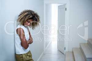 Tensed woman leaning on wall