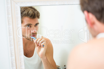 Young man brushing teeth