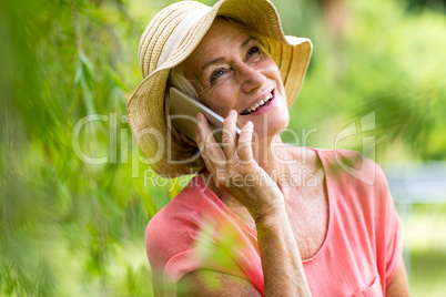 Senior woman using phone in yard