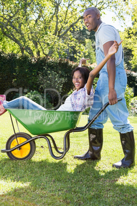 Young man giving woman a ride in the wheelbarrow