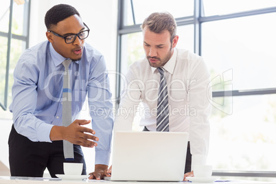 Businessmen using laptop at desk