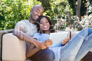 Young couple relaxing on the sofa and using digital tablet