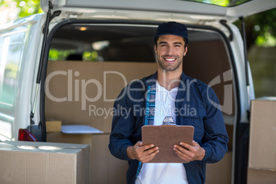 Portrait of smart delivery man holding clipboard