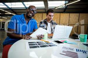 Colleagues using digital tablet and laptop