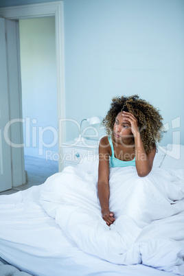 Tensed woman sitting on bed in bedroom Tensed woman sitting on bed in bedroom