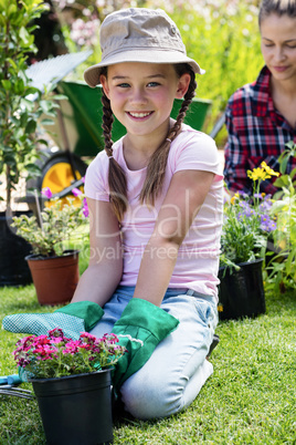 Portrait of girl sitting in garden with flower pot