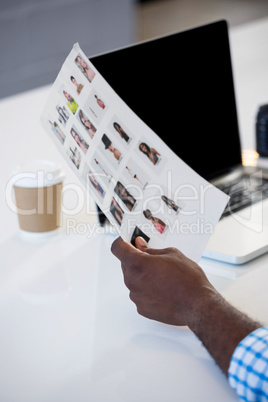 Man holding a chart with laptop on desk