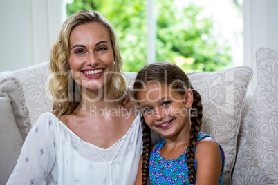 Cheerful mother with daughter on sofa