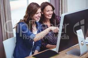 Two beautiful woman using computer