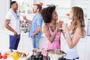 Friends having wine in kitchen