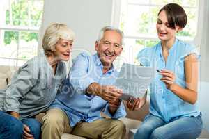 Smiling female consultant showing report to senior couple