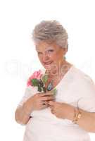 Senior woman holding pink rose.