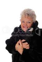Senior woman having fun with her fur coat.