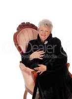 Senior woman sitting in armchair.