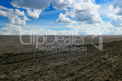 plowed field and cloudy sky