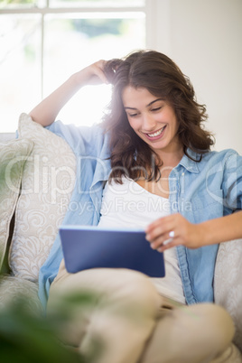 Woman using a digital tablet in living room