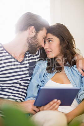 Couple with a digital tablet embracing each other