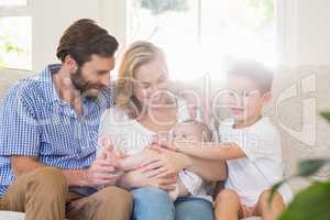 Parents sitting on sofa with their kids