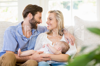 Parents sitting on sofa with their child