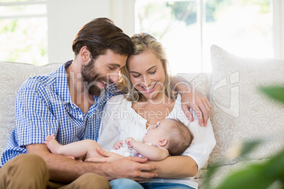 Parents sitting on sofa with their child