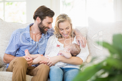 Parents sitting on sofa with their child