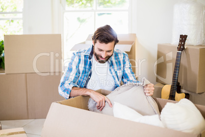 Young man unpacking carton boxes