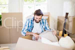 Young man unpacking carton boxes