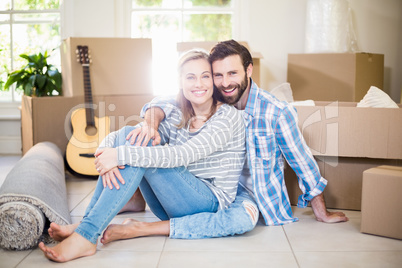 Portrait of smiling couple sitting on floor