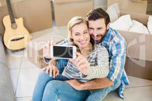 Couple sitting on floor and taking selfie