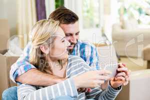 Couple using mobile phone in living room