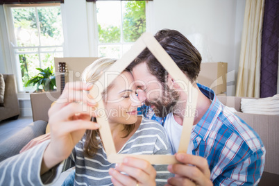 Couple embracing while holding popsicle in living room