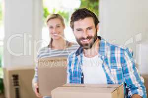 Portrait of young couple holding cardboard boxes