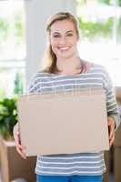 Portrait of young woman holding cardboard boxes