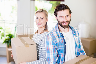 Portrait of young couple holding cardboard boxes