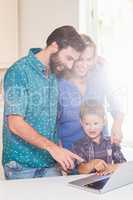 Happy parents and son using laptop