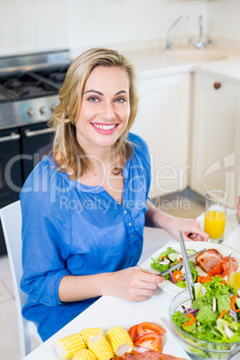 Young woman sitting at dining table smiling