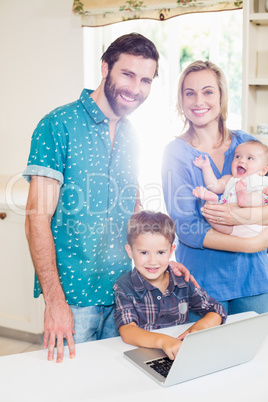 Happy parents and kids using laptop