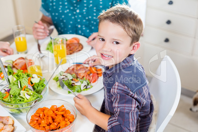 Boy sitting at dining table smiling