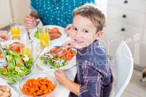 Boy sitting at dining table smiling