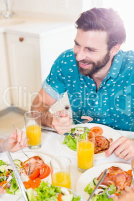 Young man sitting at dining table smiling