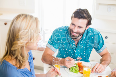 Young couple sitting at dining table talking