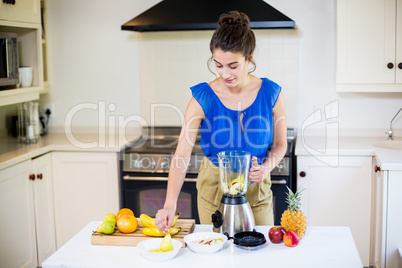 Beautiful young woman preparing juice