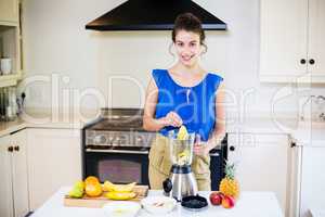 Beautiful young woman preparing juice