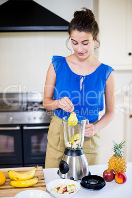 Beautiful young woman preparing juice